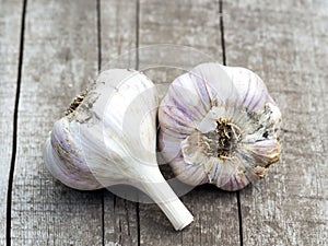 Organic garlic bulbs on a wooden table in the background
