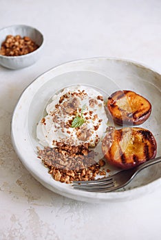 Organic grilled peaches served with stracciatella cheese and caramelized nuts crumb