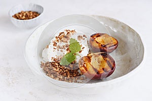 Organic grilled peaches served with stracciatella cheese and caramelized nuts crumb