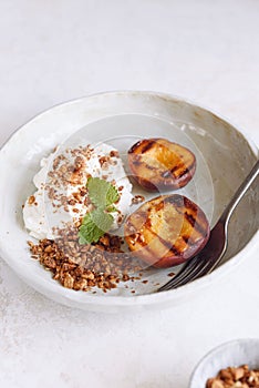 Organic grilled peaches served with stracciatella cheese and caramelized nuts crumb