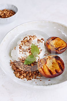 Organic grilled peaches served with stracciatella cheese and caramelized nuts crumb