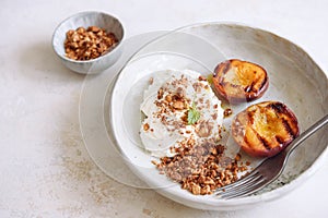 Organic grilled peaches served with stracciatella cheese and caramelized nuts crumb