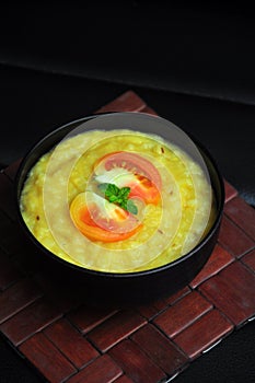 Organic healthy yellow khichdi on black background