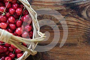 Organic homegrown cherries in a basket, on wooden background