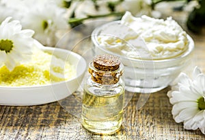 organic cosmetics with camomile extract on wooden table background