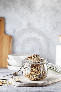 Organic homemade granola cereal with oats, nuts and dried berries. Muesli in a glass jar. Healthy vegan breakfast or snack. Copy