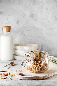 Organic homemade granola cereal with oats, nuts and dried berries. Muesli in a glass jar. Healthy vegan breakfast or snack. Copy