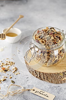 Organic homemade granola cereal with oats, nuts and dried berries. Muesli in a glass jar. Healthy vegan breakfast or snack. Copy