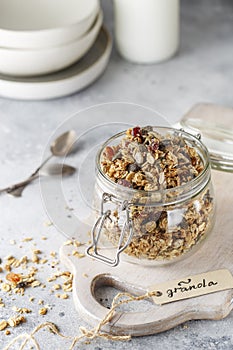 Organic homemade granola cereal with oats, nuts and dried berries. Muesli in a glass jar. Healthy vegan breakfast or snack. Copy