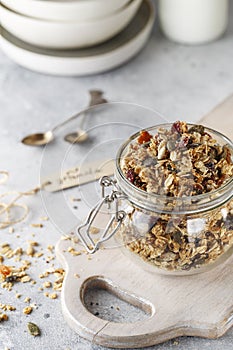 Organic homemade granola cereal with oats, nuts and dried berries. Muesli in a glass jar. Healthy vegan breakfast or snack. Copy