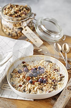 Organic homemade granola cereal with oats, nuts and dried berries. Muesli in a glass jar. Healthy vegan breakfast or snack. Copy