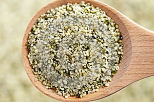 Organic hulled hemp seeds in wooden spoon. Natural nutritional supplement