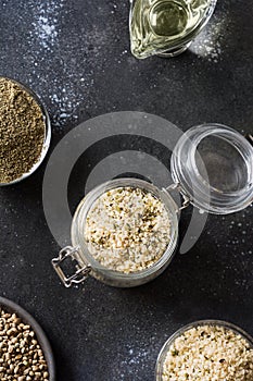 Organic kernels hemp in glass jar on black. Vertical format