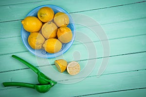 Organic lemons and juice squeezer on table