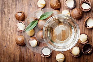 Organic macadamia nuts and oil on wooden rustic table top view.