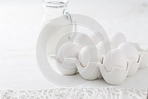 Organic milk and fresh eggs on white kitchen table