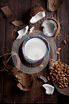 Organic milk made of coconuts and almonds on rustic wooden table texture