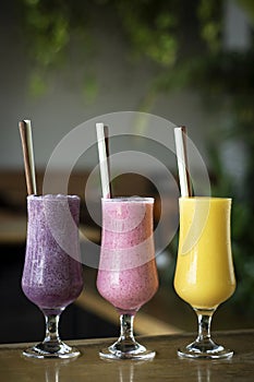 Organic mixed fresh fruit smoothie glasses on cafe table