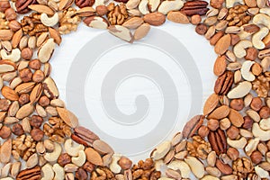 Organic mixed nuts banner with place for text in the shape of a heart. Assorted nuts: hazelnuts walnuts, brazilian nuts, pecans,