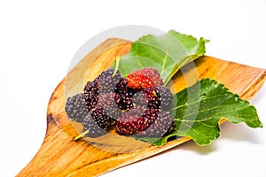 Organic mulberry fruit on a plank isolated