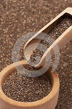 Organic natural chia seeds, wooden scoop and bowl close-up