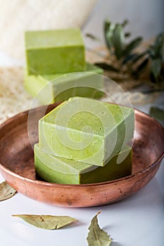 Organic natural handmade bay laurel soap with olive oil and leaves on white background.