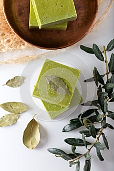 Organic natural handmade bay laurel soap with olive oil and leaves on white background.