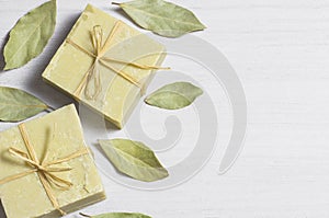 Organic natural handmade bay laurel soap with olive oil and leaves on white rustic backdrop