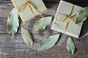 Organic natural handmade bay laurel soap with olive oil and leaves on wooden rustic backdrop