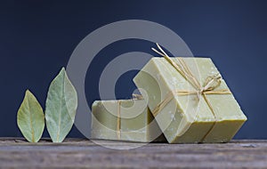 Organic natural handmade bay laurel soap with olive oil and leaves on wooden rustic backdrop