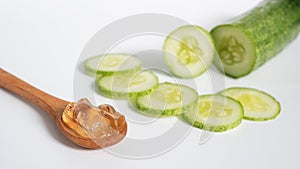 Organic natural skincare concept. clear transparent gel in wooden spoon with cucumber slice isolated on white background