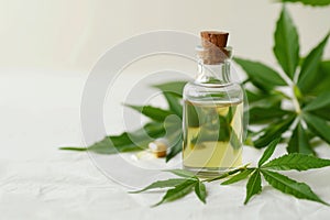 Organic neem oil and fresh leaves on natural background