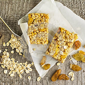 Organic oat cereal bars with honey and Golden raisins on a simple wooden background. Top view