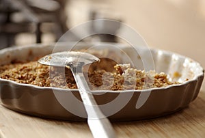 Organic oatmeal porridge in white ceramic bowl with apple, almond, honey and cinnamon.