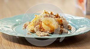 Organic oatmeal porridge in white ceramic bowl with apple, almond, honey and cinnamon.