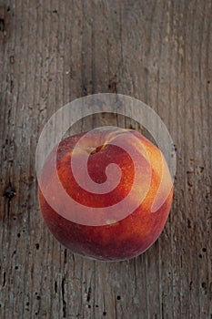 Organic peach on an old wooden board