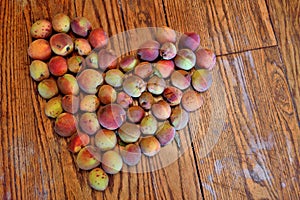 Organic peaches in heart shape agianst wood background