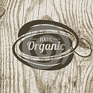 Organic product badge with leaves on wooden texture. Vector illustration background. Logo template