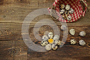 Organic quail eggs and yolk in the form of a flower and quail eggs in basket on a wooden rustic background with copy space