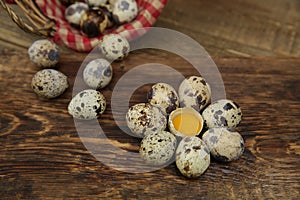 Organic quail eggs and yolk in the form of a flower and quail eggs in basket on a wooden rustic background with copy space