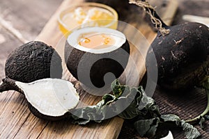 Organic raw Black radish with honey on wooden table. Homemade cough medicine. Folk remedy for immunity