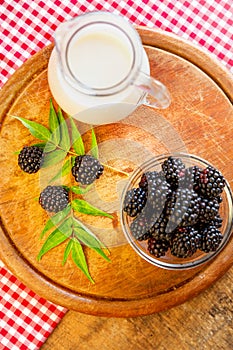 Organic raw blackberries next to milk.