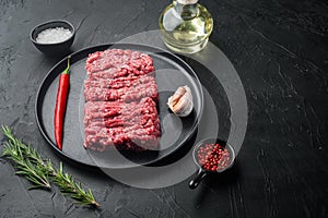 Organic Raw Grass Fed Ground Beef, on black background with copy space for text