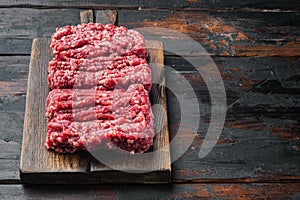 Organic Raw Grass Fed Ground Beef, on old dark  wooden table background  with copy space for text