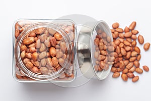 Organic red brown peanuts Arachis hypogaea in a glass jar with Lid