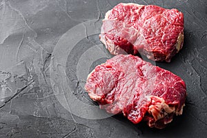 Organic rump steaks over black background, side view with space for text