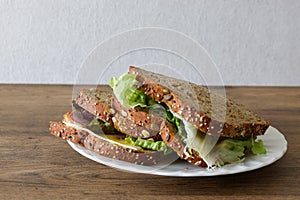 Organic sandwich on a plate isolated on a wooden background