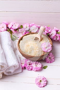 Organic sea salt in bowl with towels and pink flowers