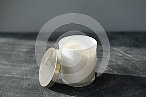 Organic soy wax candle in a glass on a grey table