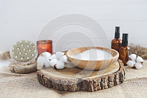 Organic spa beauty products and natural skin care concept. Set of natural oils, facial scrub, brush, candle and cotton on a wooden